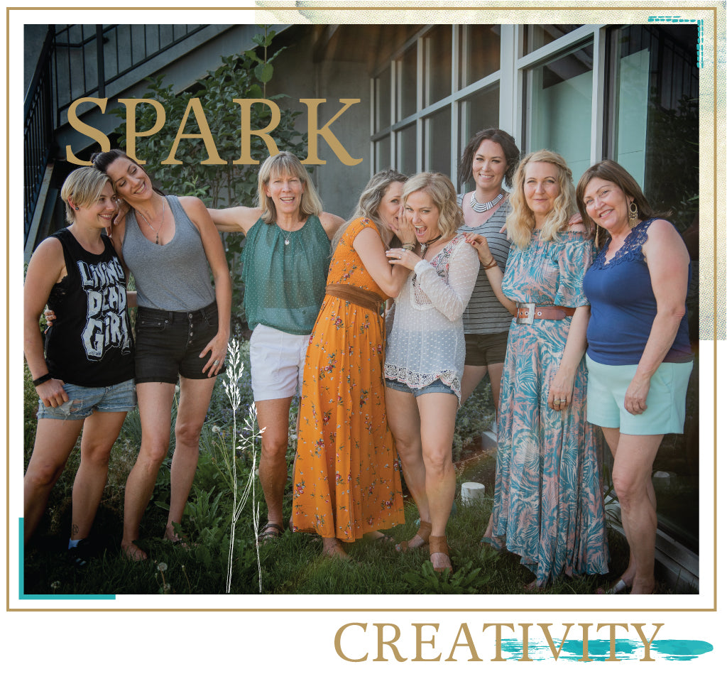 Eight women standing dressed in boho attire posing for photo with a decorative border. Text overlay reads "Spark Creativity".