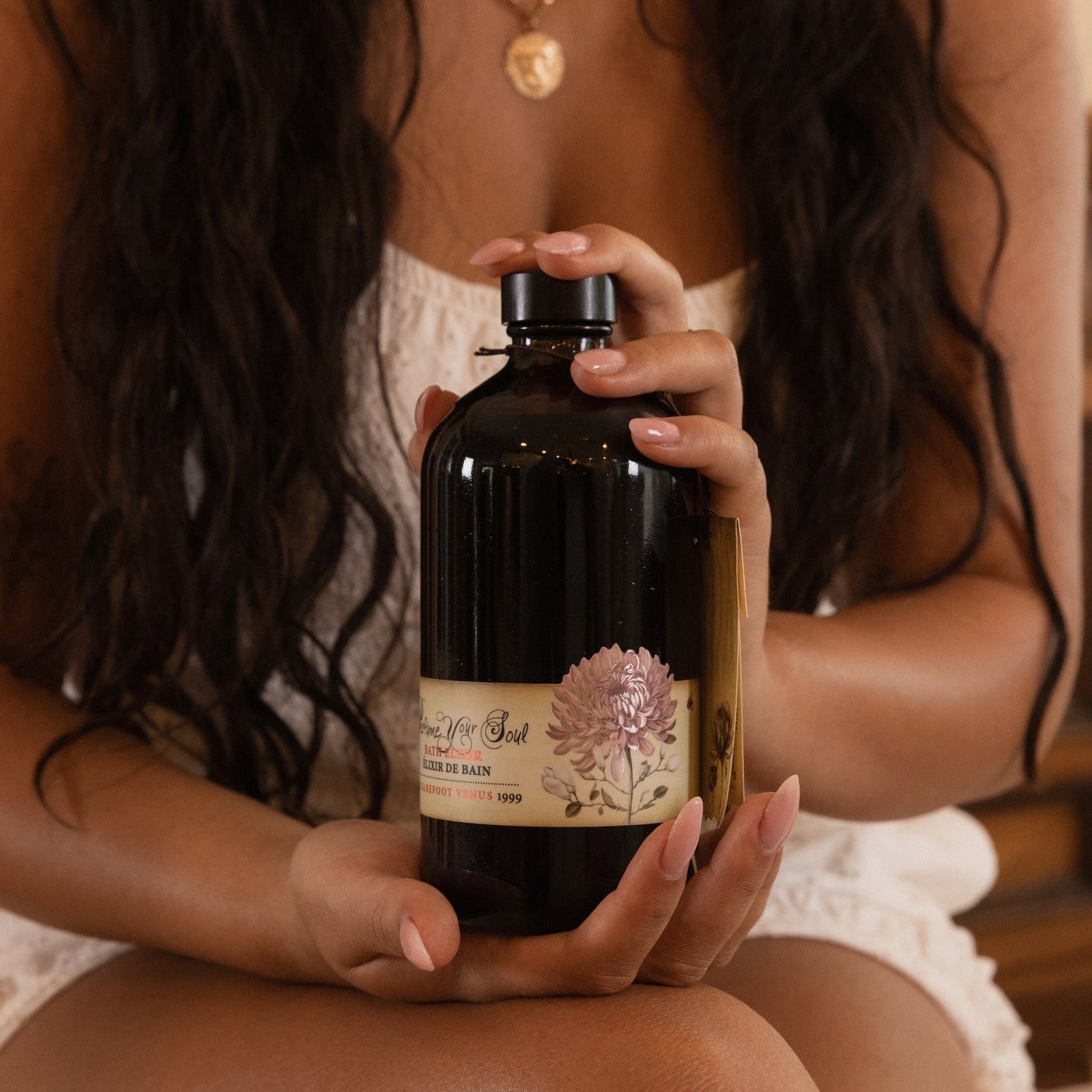 Bottle of Barefoot Venus bath elixir with a label on a white background