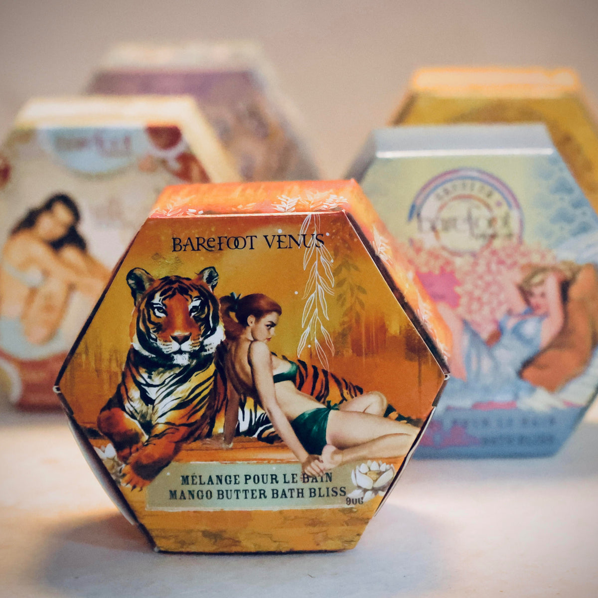 Hexagonal Barefoot Venus soap packaging with tiger and woman design, surrounded by other similar products.